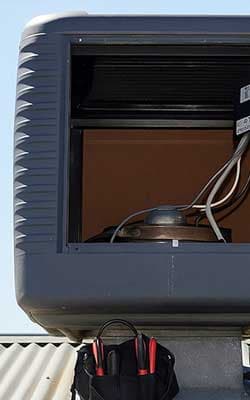 Technician opening an evaporative cooler for repair